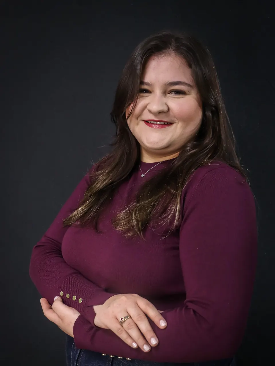 Millena Vantroba, especialista em BPO financeiro da Vantroba Group, sorrindo de braços cruzados