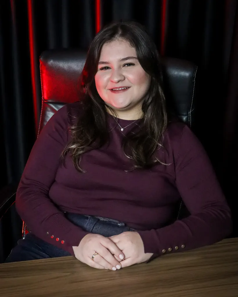 Millena Vantroba sentada à mesa do escritório da Vantroba Group